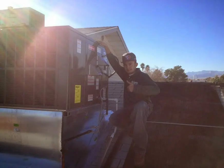 HVAC technician performing Boiler Repair on a rooftop unit in Jacinto City